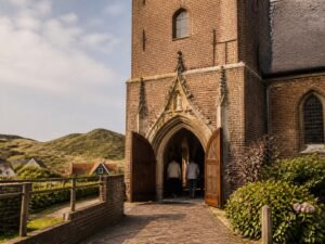 Open deuren van een historische kerk bij de duinen